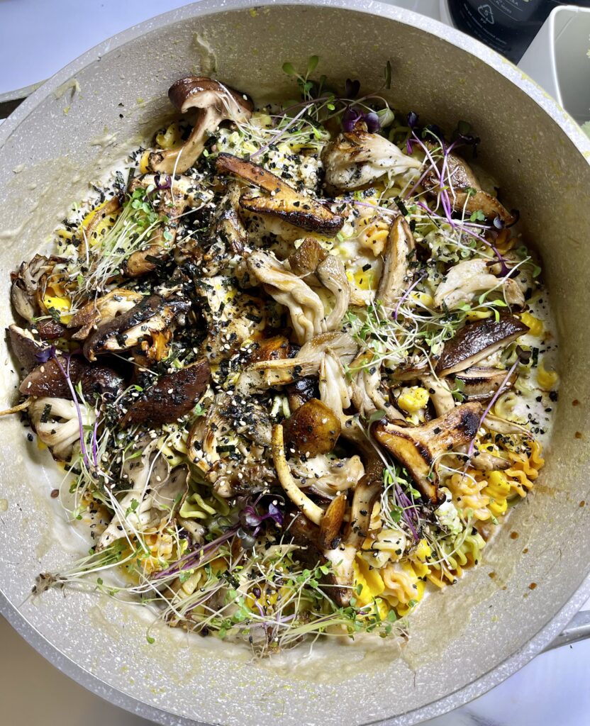 Creamy vegan mac and cheese with cashew sauce, mushrooms, truffle oil, and microgreens