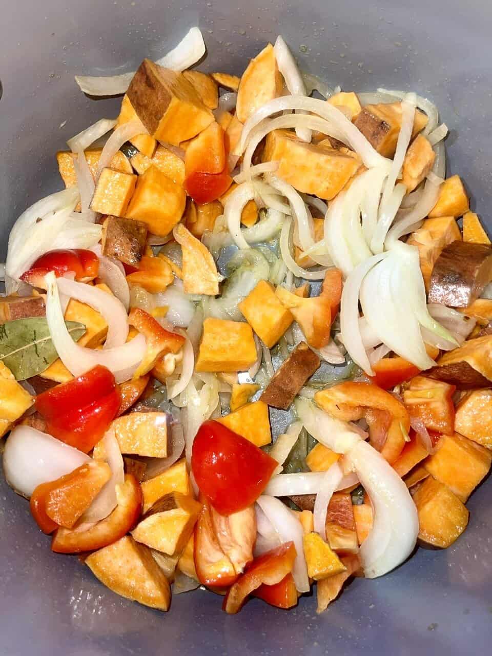 Sweet potatoes, onions, and tomatoes being sautéed, promoting healthy cooking for a pure, loving heart.
