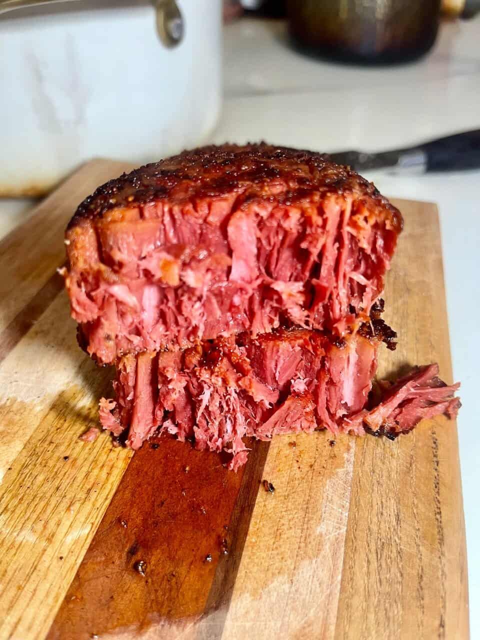 Cross-section of a seared Juicy Marbles plant-based filet showing juicy pink fibers on a wooden cutting board