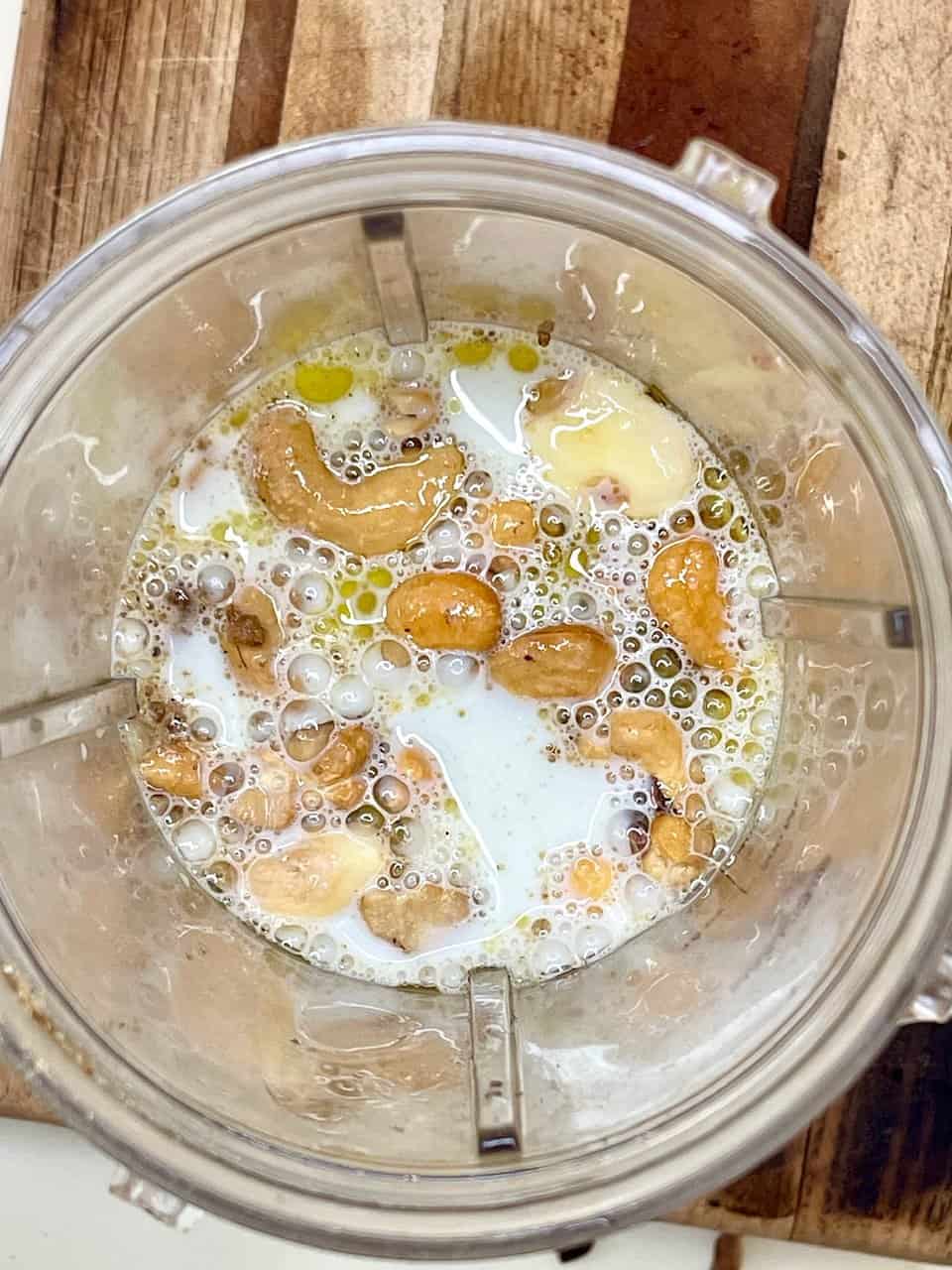 Almond milk and vanilla protein powder in blender for healthy smoothie drink.