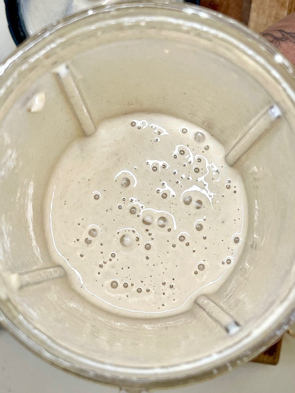 Creamy plant-based smoothie mixture in blender, healthy vegan drink recipe.