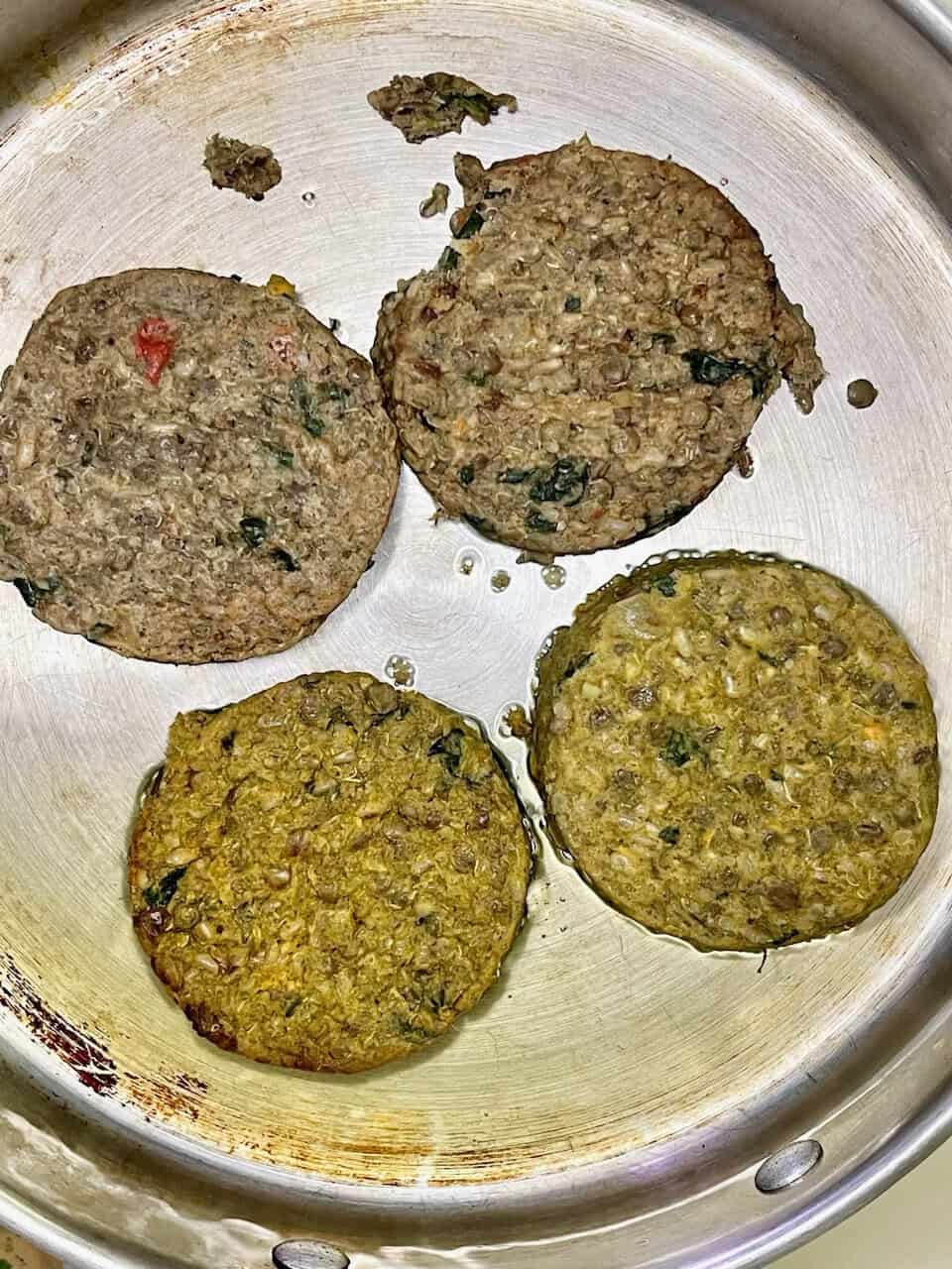 Fresh plant-based veggie patties cooking in a skillet, promoting healthy eating and mindful food choices.