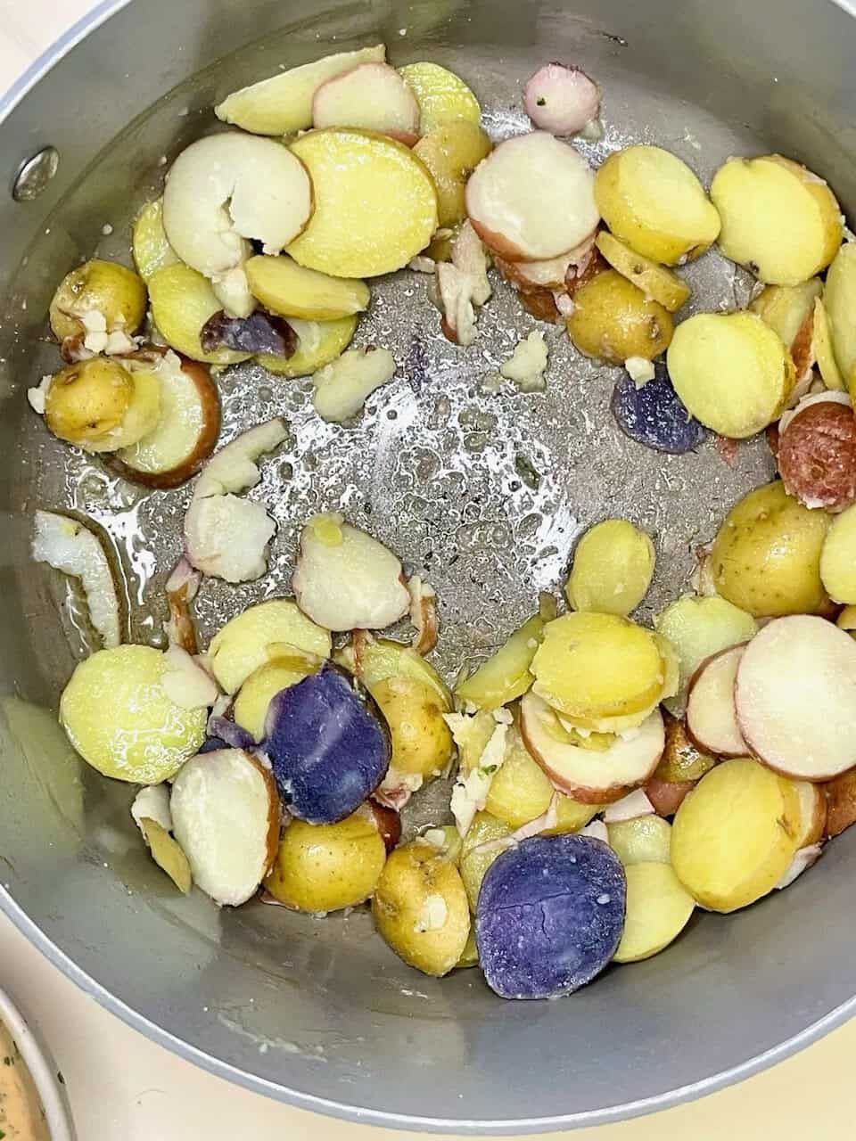 Sweet potatoes and purple yams cooking in a skillet for a nutritious, plant-based meal.