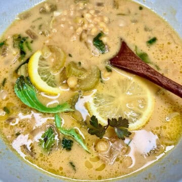 Creamy lemon lentil soup with fresh herbs and vegetables, perfect for healthy, nourishing vegetarian meals.