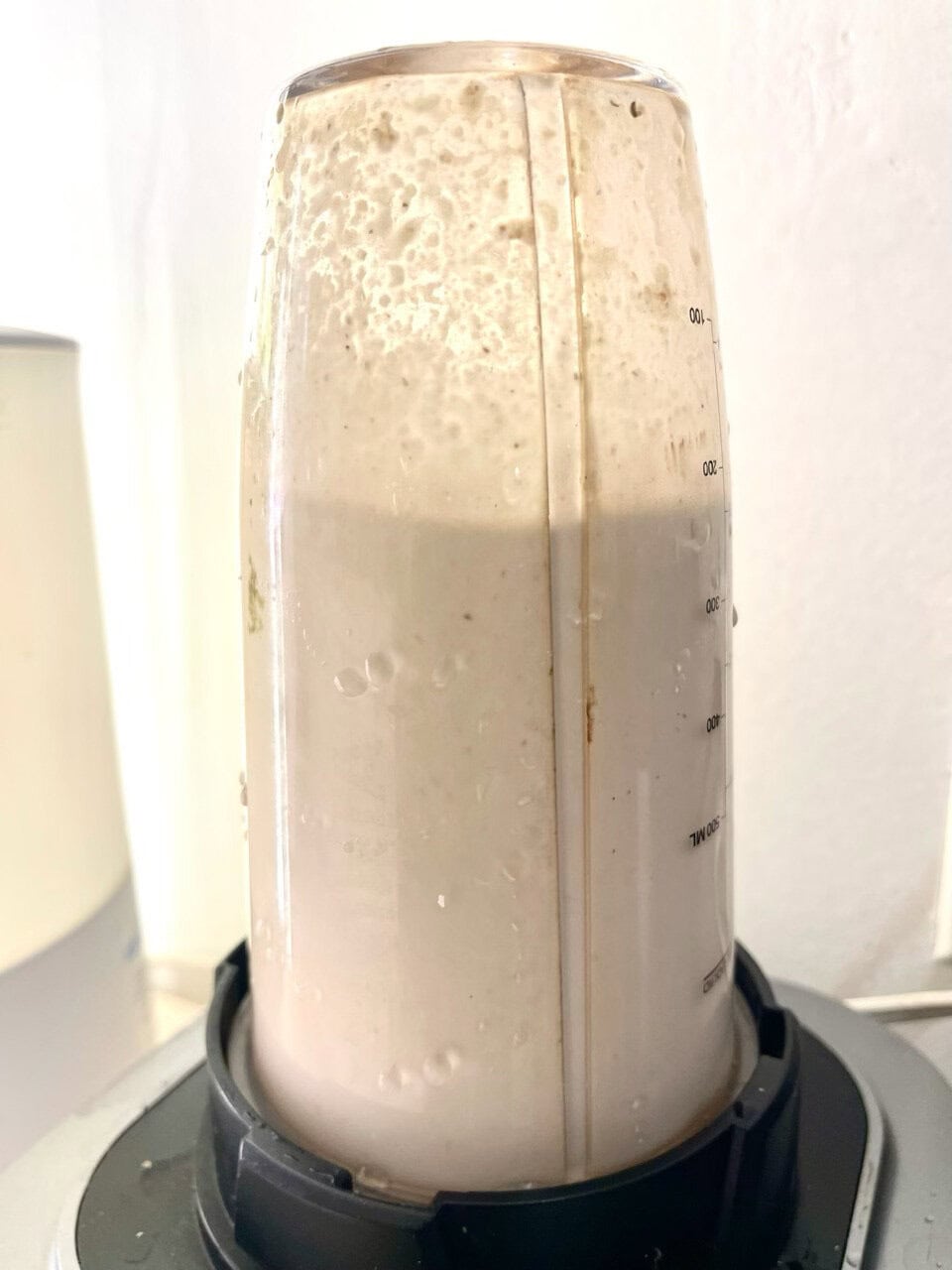 Creamy blended smoothie in a clear blender bottle, highlighting healthy, plant-based nutrition.