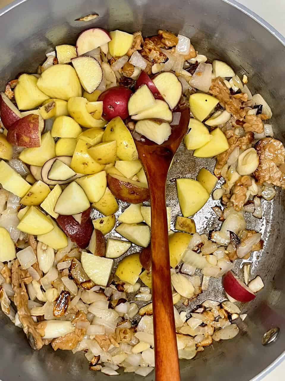 Freshly chopped apples and onions cooking in a skillet, creating a flavorful base for healthy recipes.