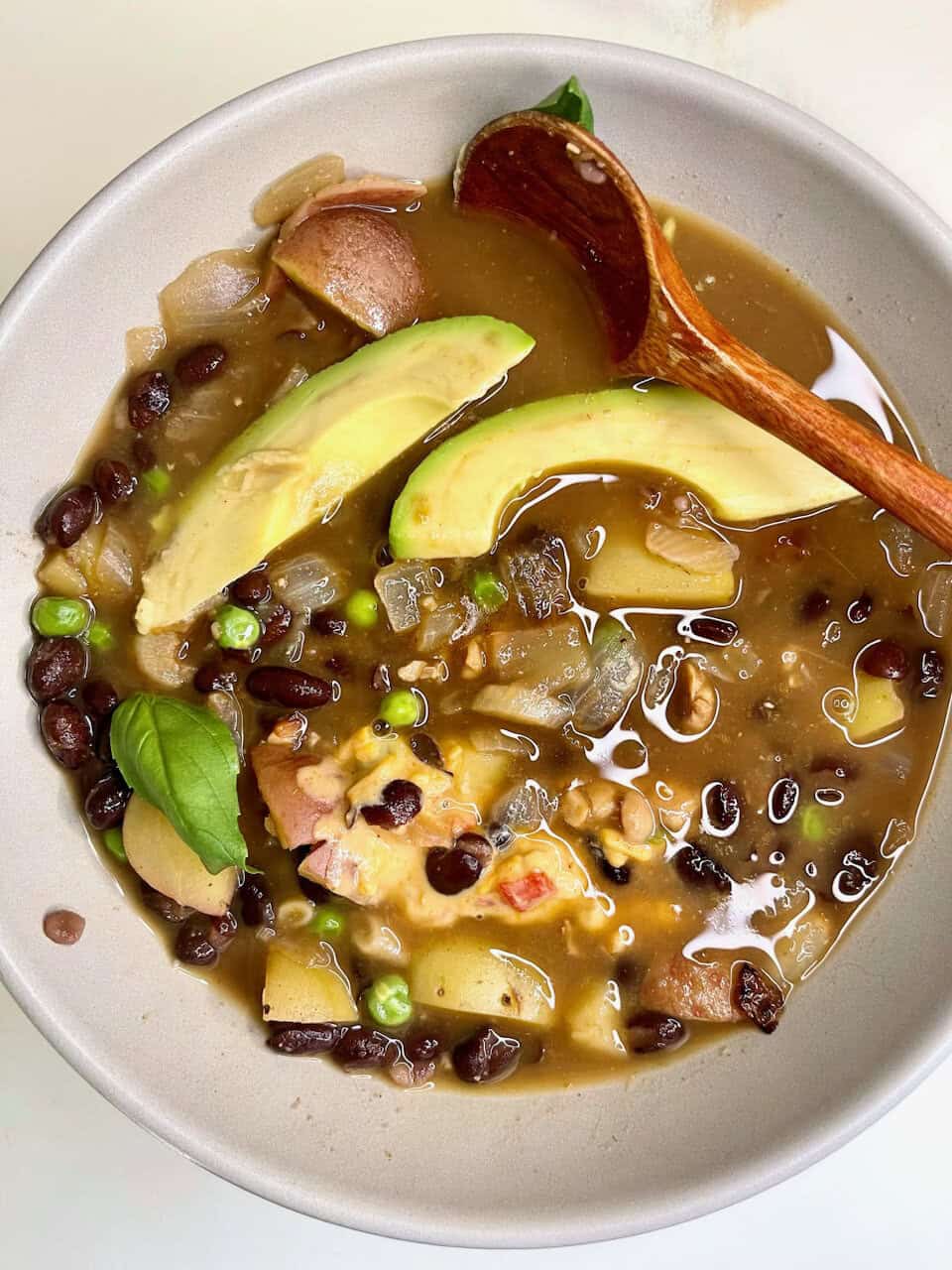 Rich vegan black bean soup with avocado and fresh herbs, healthy and satisfying plant-based meal.