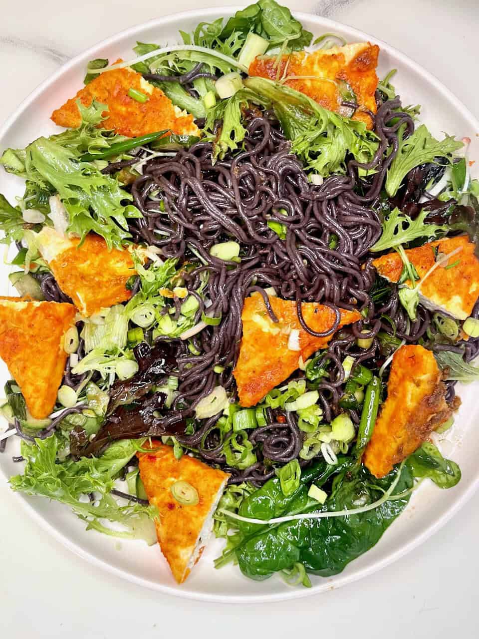 Black salt noodles salad with vibrant greens and crispy tofu pieces, healthy vegan meal, Make Pure Thy Heart dietary choice.