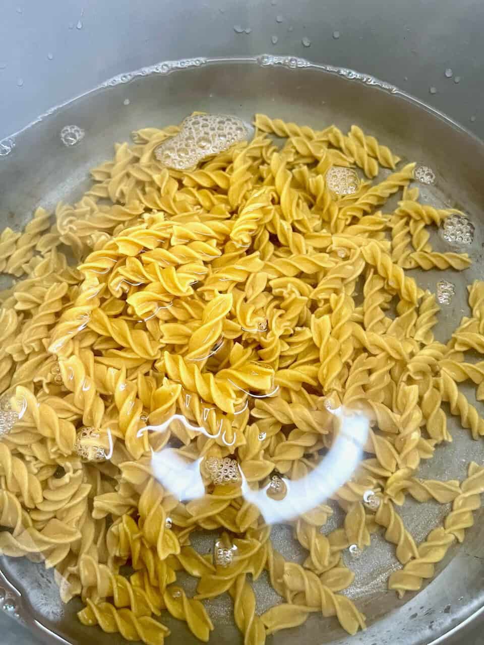 Fusilli pasta boiling in water for healthy plant-based meal, nutritious gluten-free pasta for vegan diet.