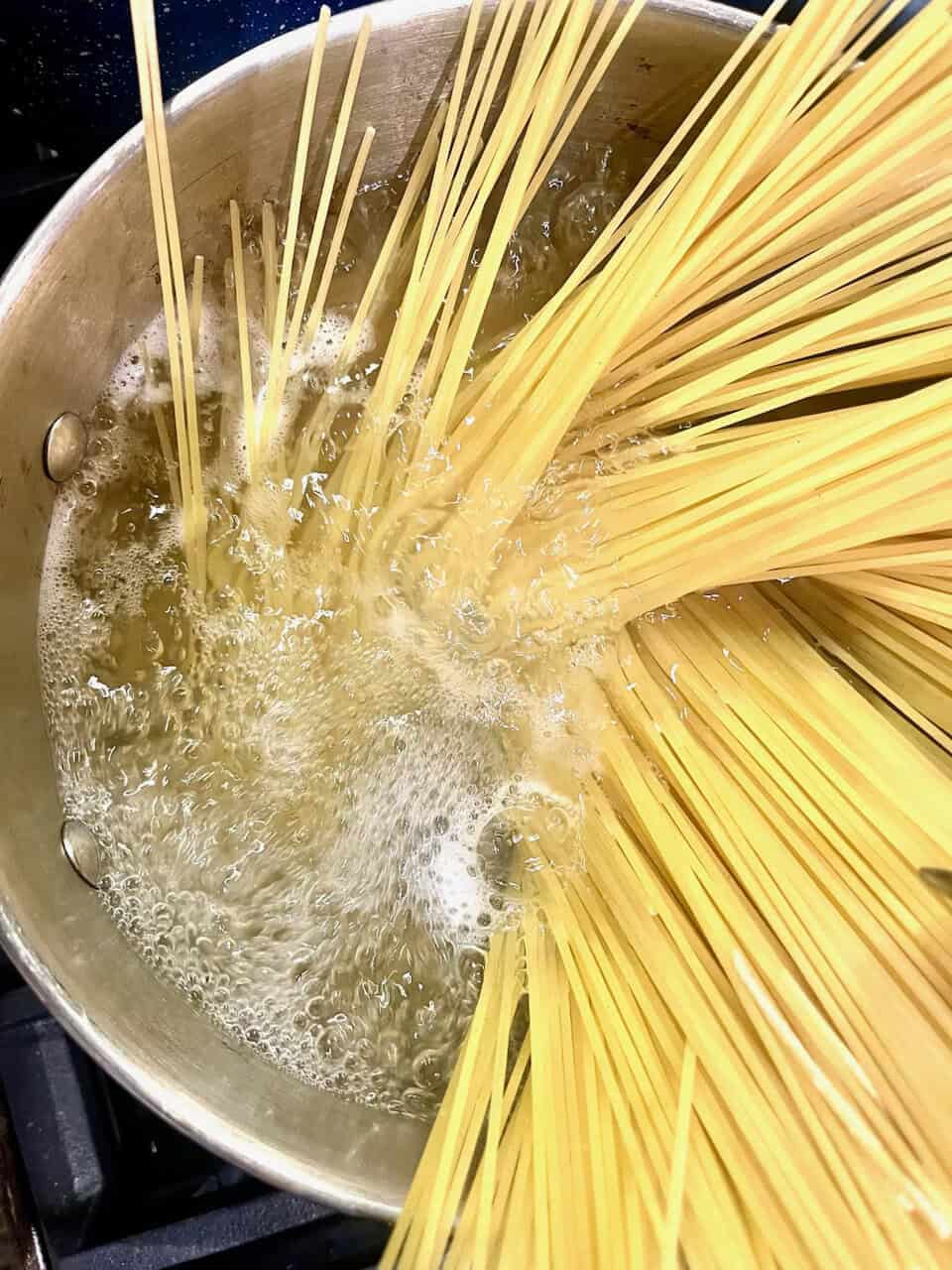 Boiling spaghetti pasta in a pot, making healthy and pure homemade pasta, culinary cooking process, raw pasta preparation, Make Pure Thy Heart recipe preparation.