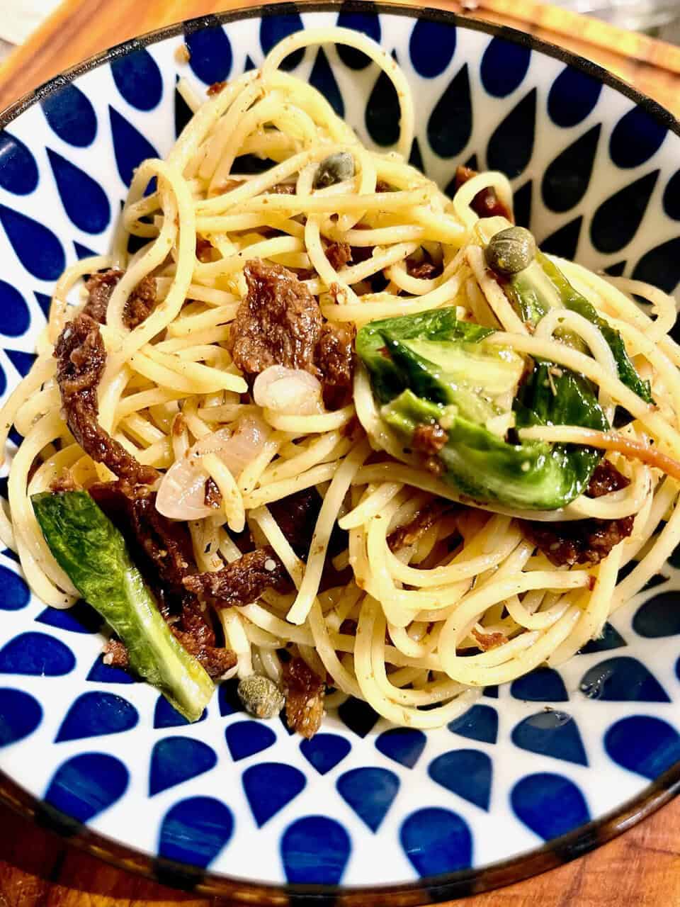 Yum vegetarian pasta with vegetables and ground meat in a decorative bowl.