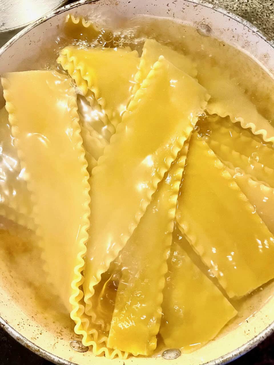 Cooked lasagna pasta boiling in water for healthy meal mastery.