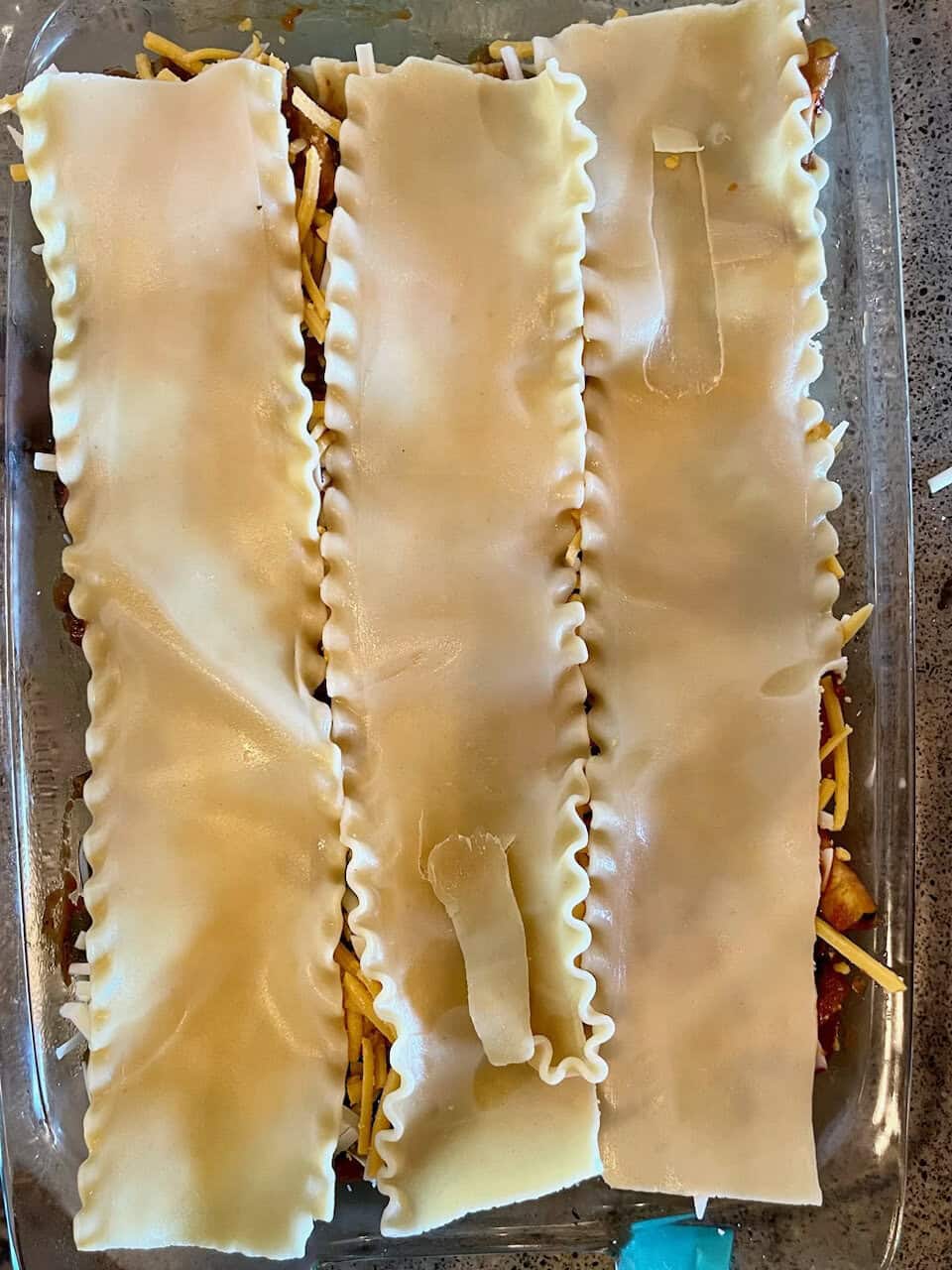 Cheese lasagna with uncooked lasagna noodles on top, ready for baking, homemade Italian pasta dish, Make Pure Thy Heart delicious recipes, comfort food.