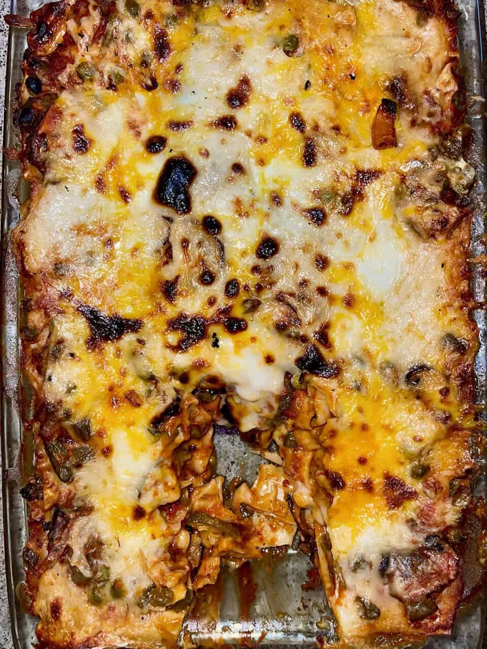 Cheesy vegetable lasagna with melted cheese and baked vegetables, homemade lasagna dish, hearty comfort food.