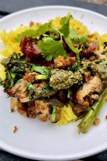 Fresh vegetable and grilled chicken on rice bowl with herbs and sauces, nourishing healthy meal for thyroid health and wellness.