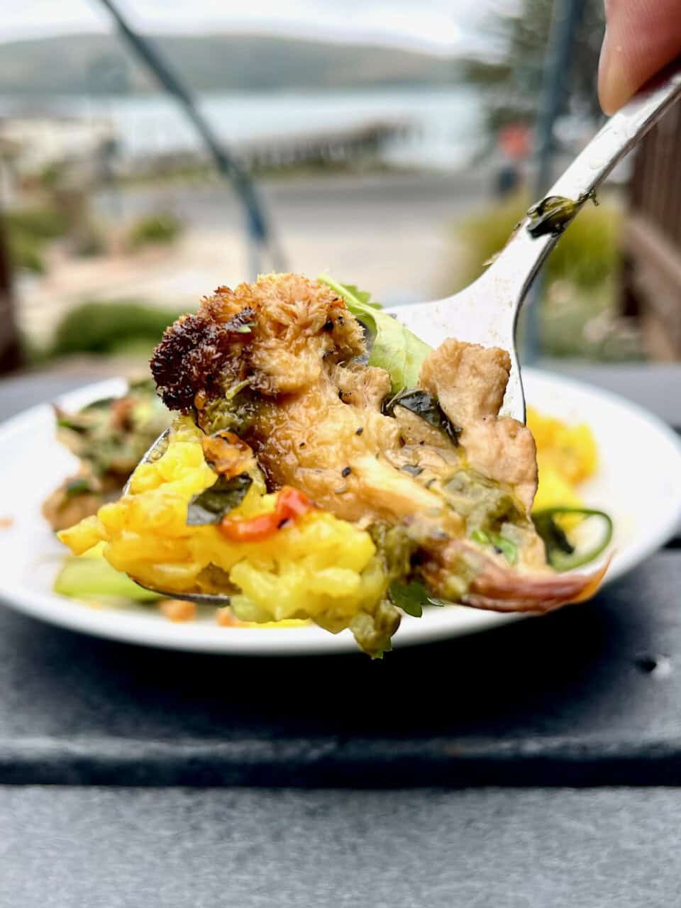 Savory vegetable scramble with herbs and spices, served fresh in a white bowl outdoors.