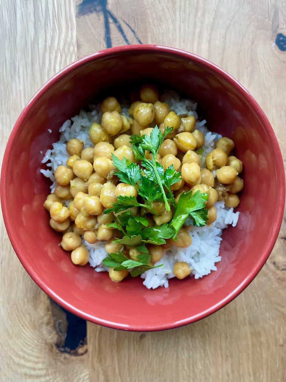Bright chickpea over fluffy white rice with fresh parsley garnish for healthy eating.