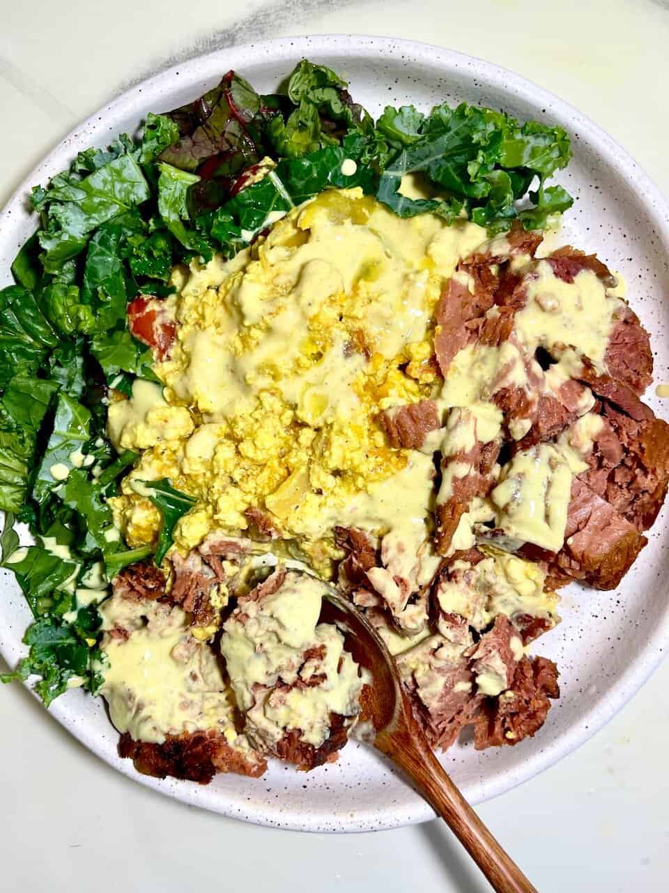 Fresh mixed greens salad with scrambled eggs and sliced roast beef drizzled with creamy dressing. Perfect healthy meal for wellness and vitality.