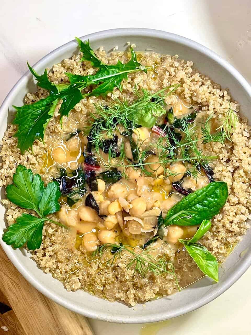 Fresh chickpea and quinoa salad garnished with mixed herbs and fresh greens, healthy and vibrant plant-based meal.