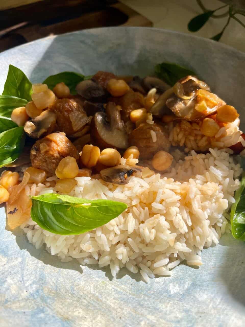 Savory mushroom and chickpea stew served with rice and fresh basil leaves, healthy vegetarian comfort food.