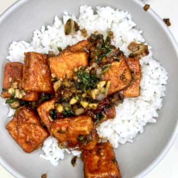 Savory tofu stir-fry with vegetables served over white rice, healthy plant-based meal, vegan recipe idea.