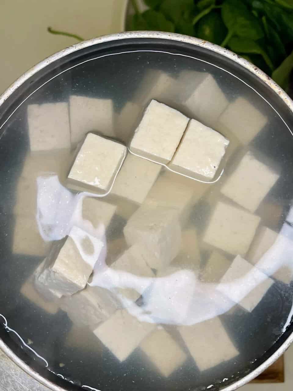 Soft tofu cubes soaking in water for healthy and natural food preparation.