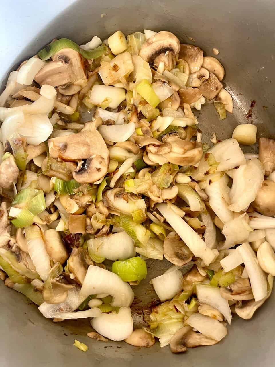 Cooked mushrooms and onions sautéed in a skillet, ready for recipe preparation or serving.