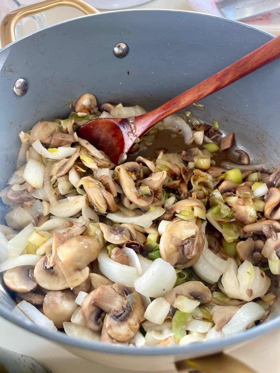 Sauteed mushrooms and onions in a frying pan, perfect for healthy eating and vegetarian recipes.