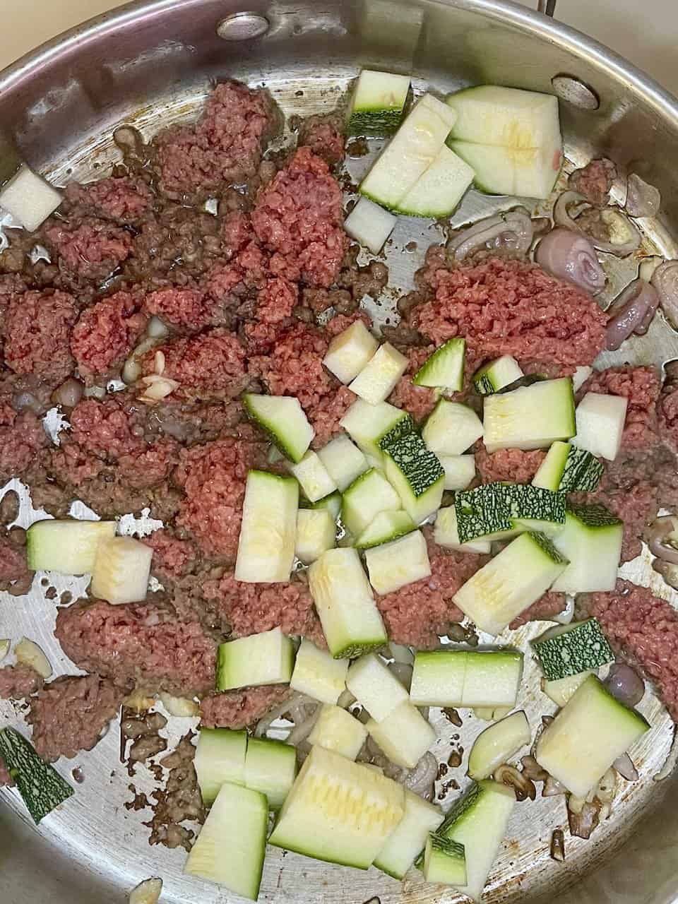 Ground beef cooking with zucchini pieces and chopped onions in a skillet, healthy meal preparation, Make Pure Thy Heart.