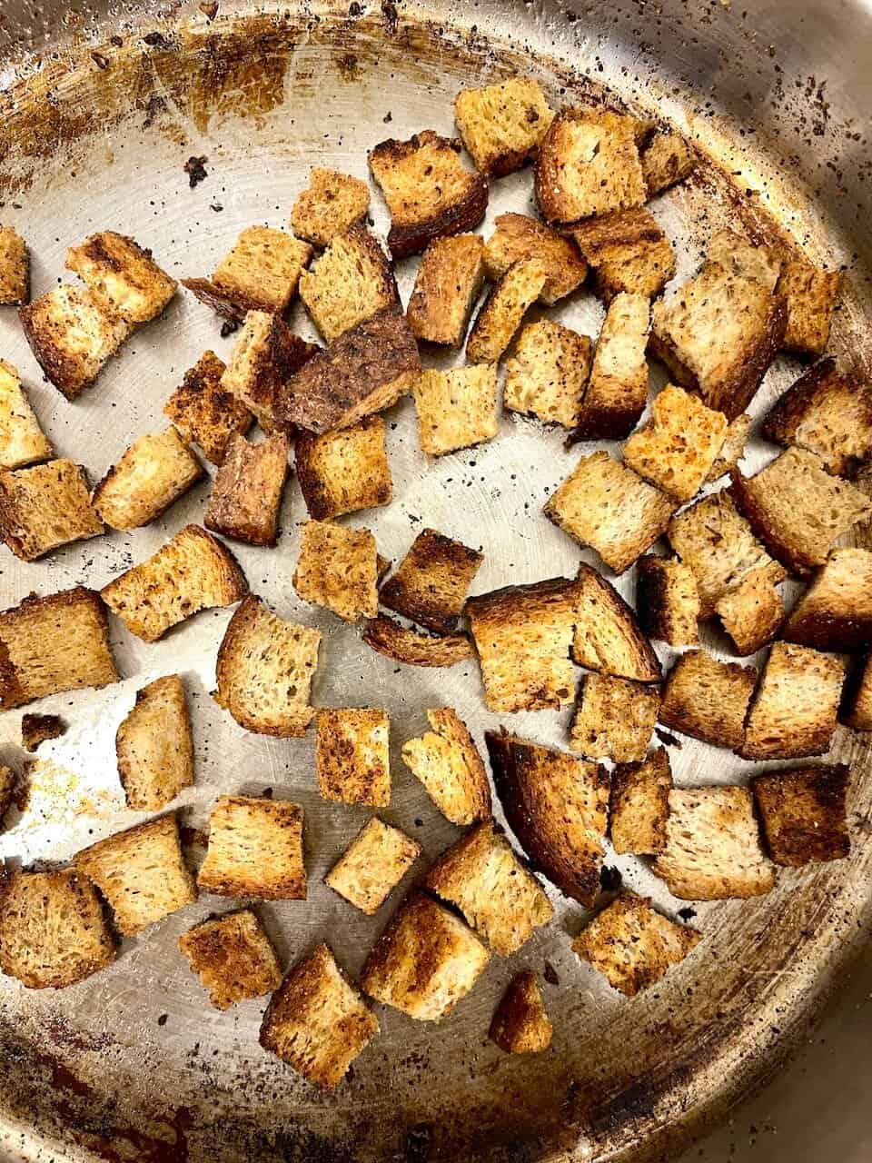 Crunchy homemade croutons on a baking sheet for salads or soups.