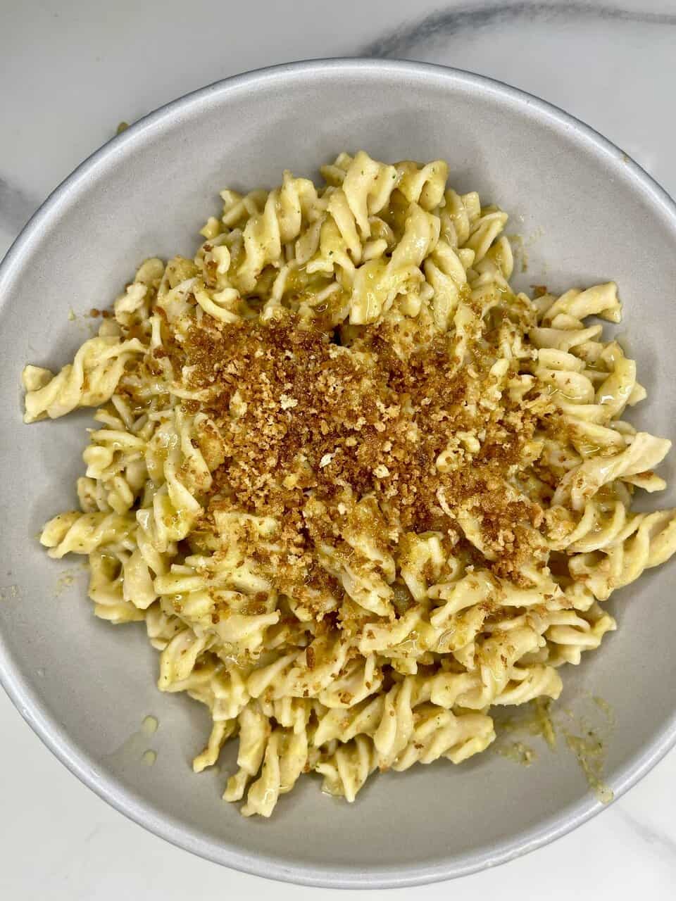 Bowl of vegan kids’ pasta with hidden vegetable sauce topped with fresh basil
