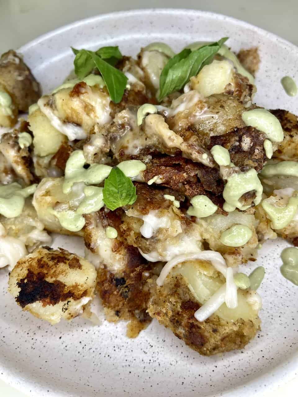 Crispy potato and meat casserole topped with green sauce and fresh basil leaves, comfort food recipe, Make Pure Thy Heart.