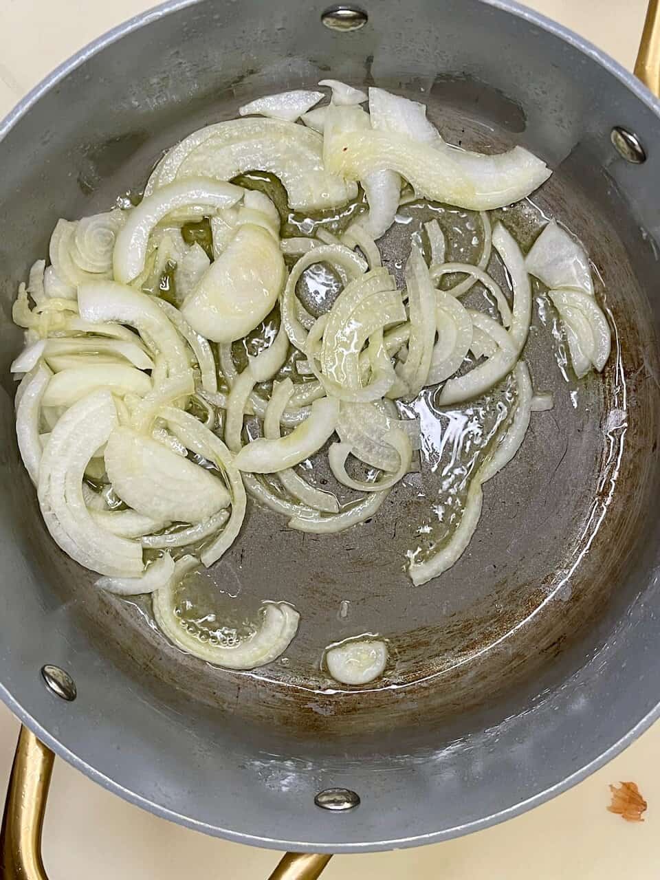 Caramelized onions cooking in a skillet for healthy meal preparation.