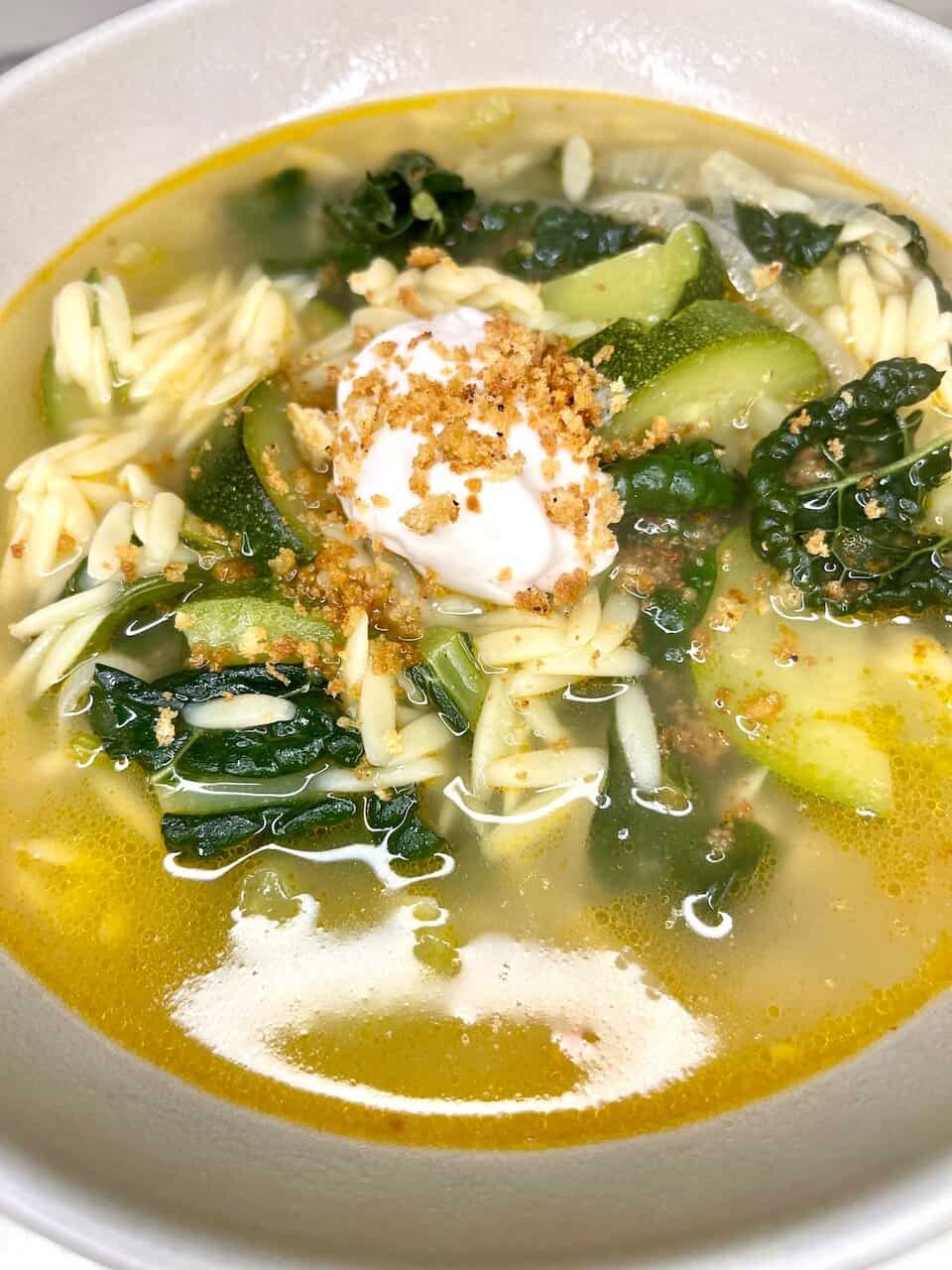 Fresh vegetable soup with greens, zucchini, pasta, topped with sour cream and crunchy seasoning.