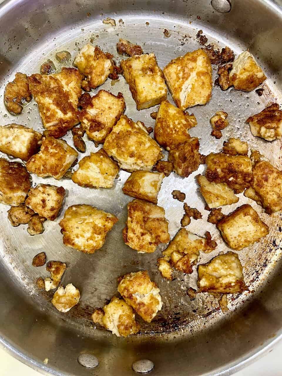 Crispy tofu cubes cooking in a stainless steel skillet, healthy plant-based protein, Make Pure Thy Heart, vegan meal preparation, gluten-free diet.