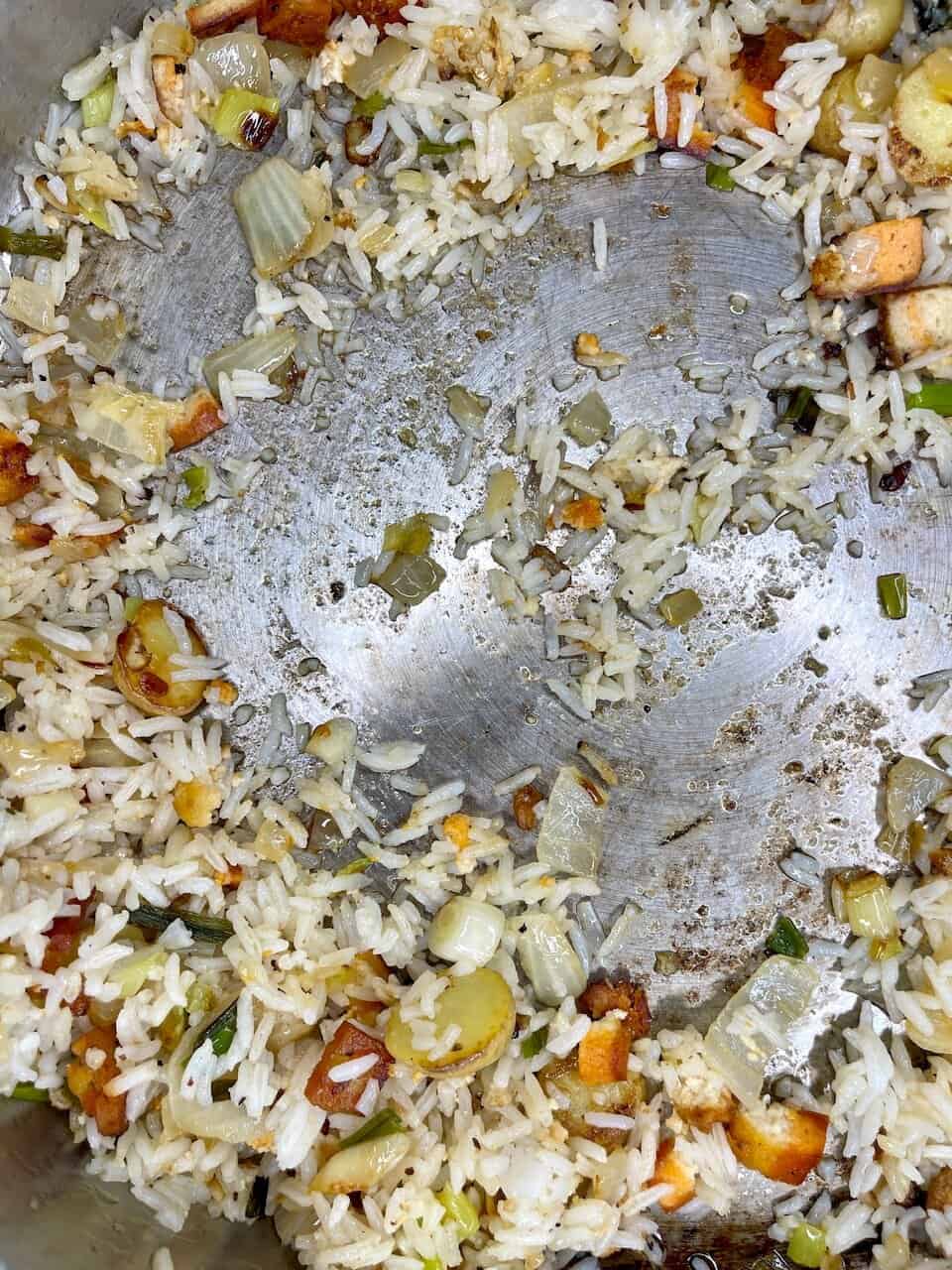 Healing rice mixed with vegetables and tofu in a cast iron skillet.