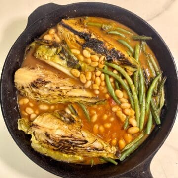 Braised hispi cabbage with green beans and white beans in a rich tomato miso broth.