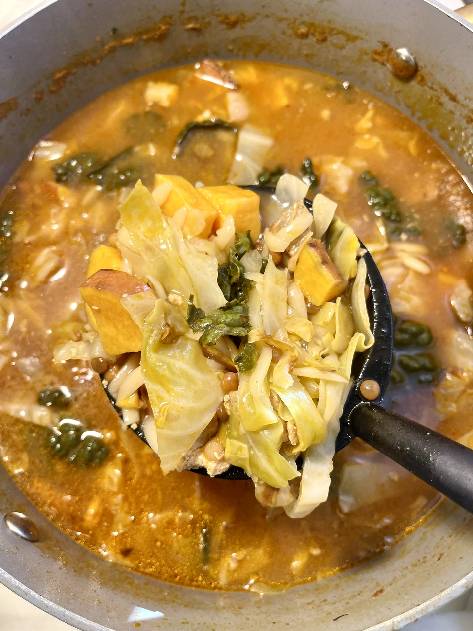 Smoky harissa lentil soup with vegetables in a pot.
