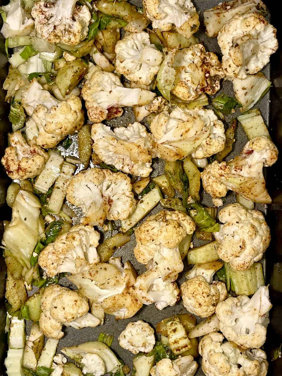 Roasted cauliflower and celery stalks in a skillet.