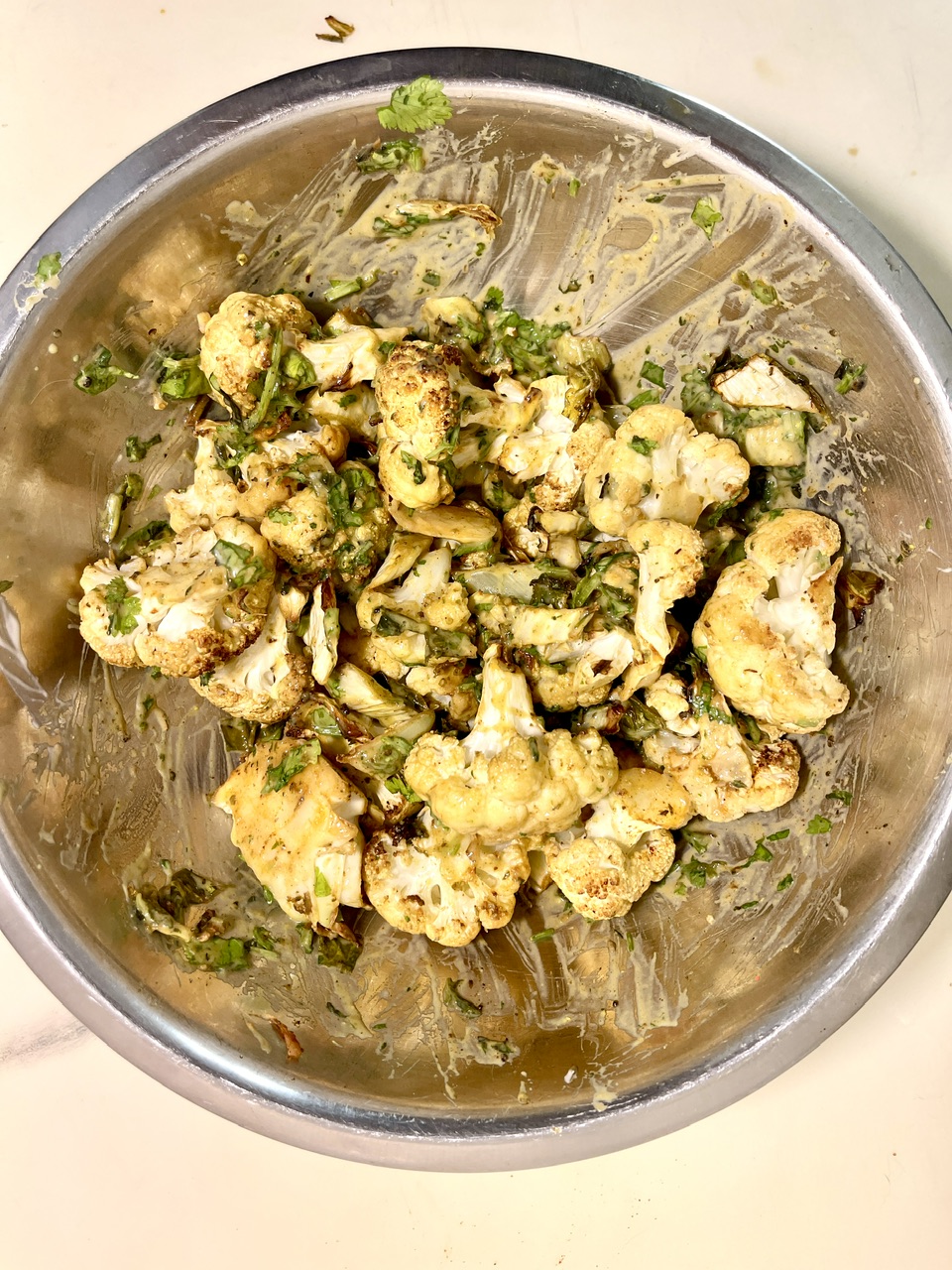 Chickpea vegan chorizo pieces with herbs in a metal bowl.