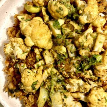 Curry cauliflower and chickpea chorizo over seasoned rice in a bowl.