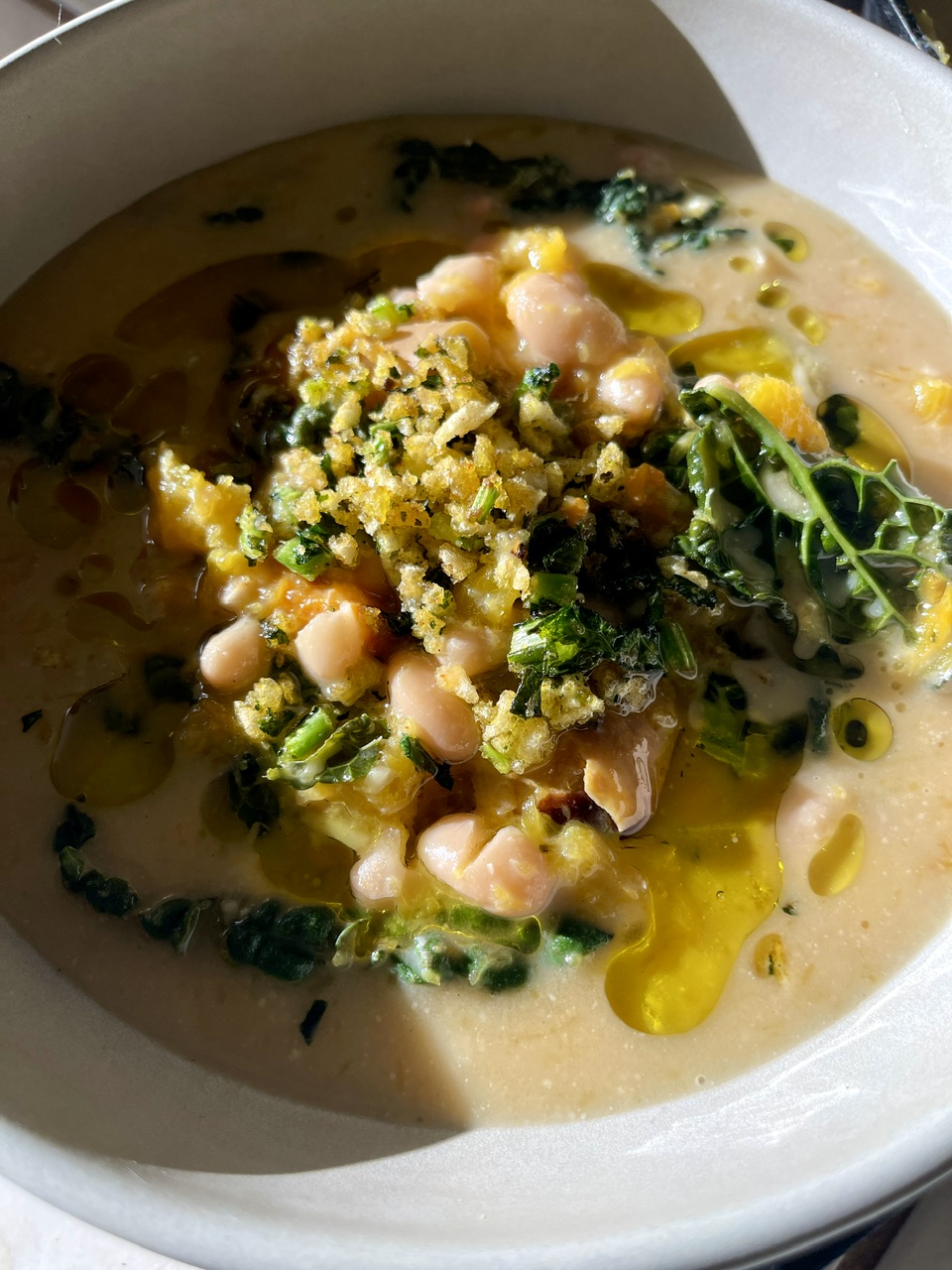 Creamy vegan soup with roasted squash, white beans, greens, and coconut-miso broth.