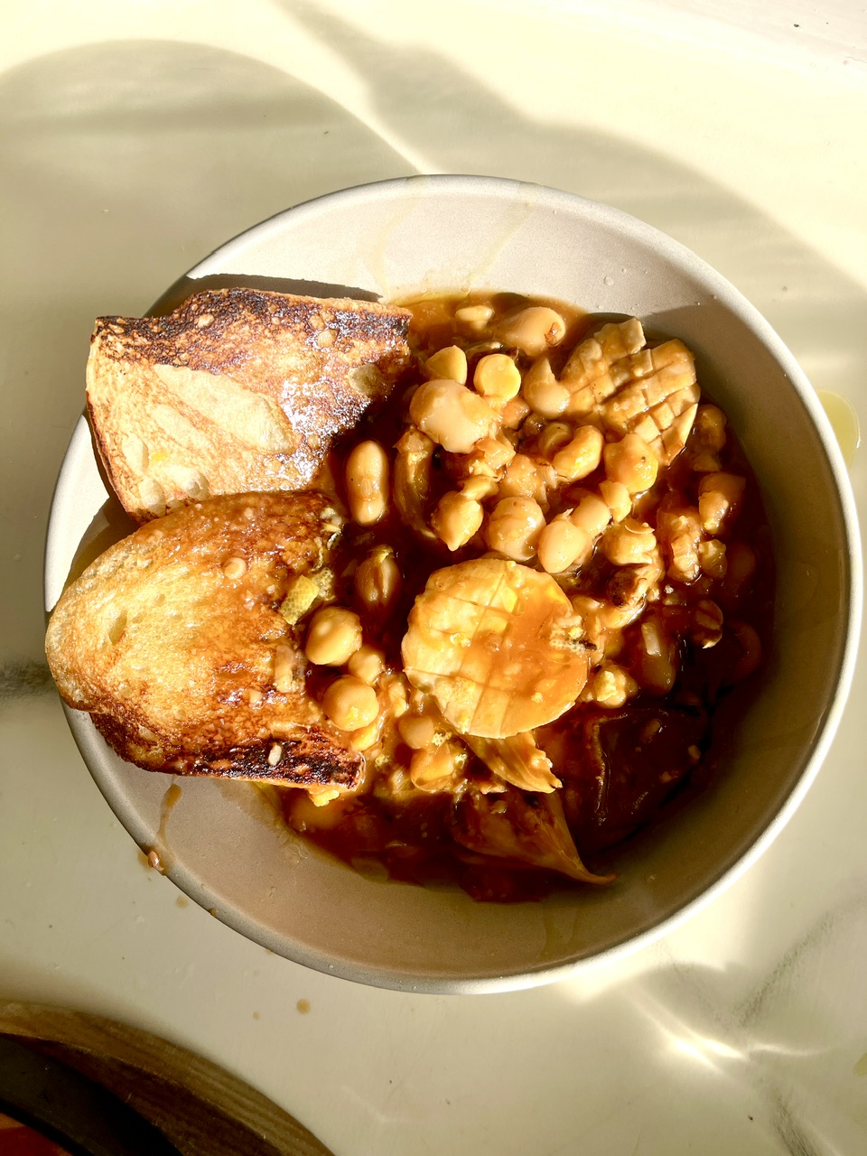Vegetarian bean dish with oyster and king trumpet mushrooms, served with toasted bread.