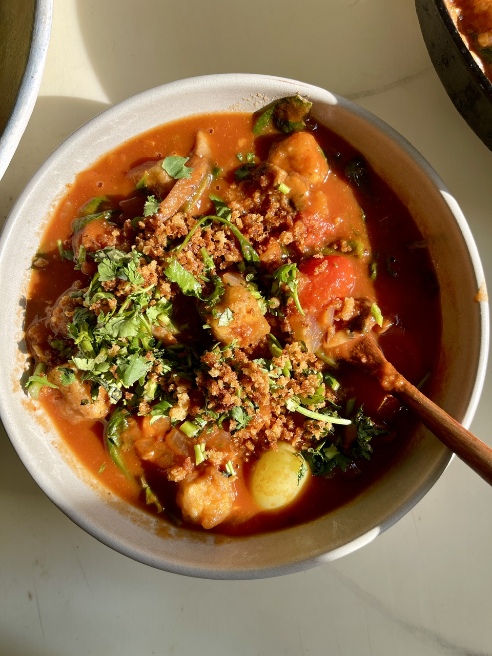 Delicious vegan biryani with crispy tofu, vegetables, and fresh herbs in a bowl.