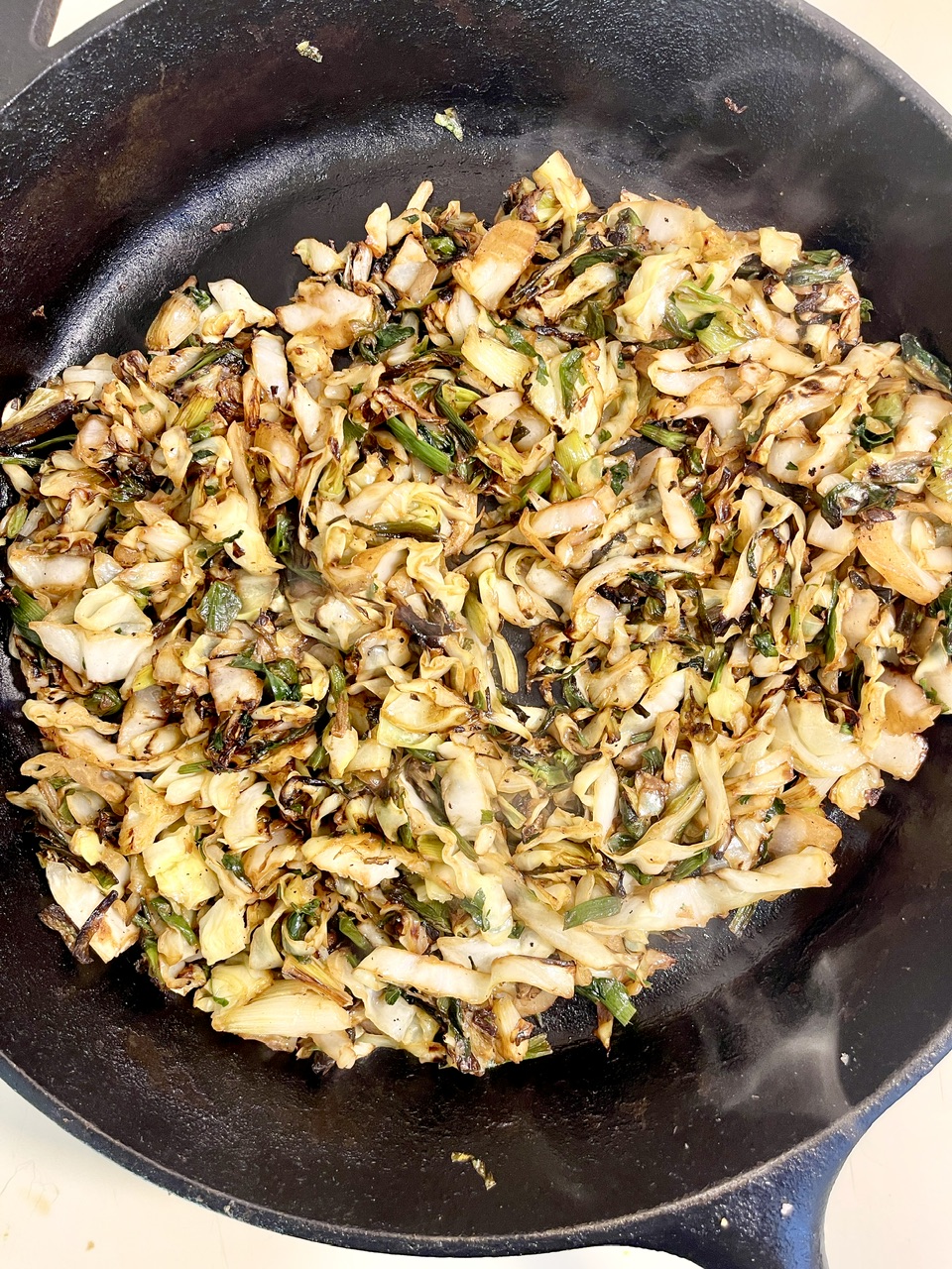 Sautéed caramelized cabbage in a skillet, perfect for pasta dishes.
