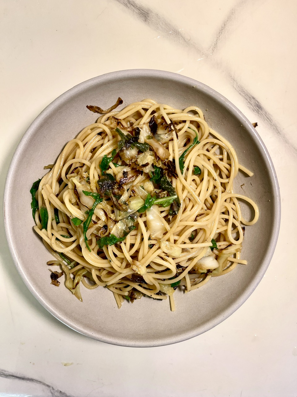 Vegetarian caramelized cabbage spaghetti with preserved lemon and arugula.