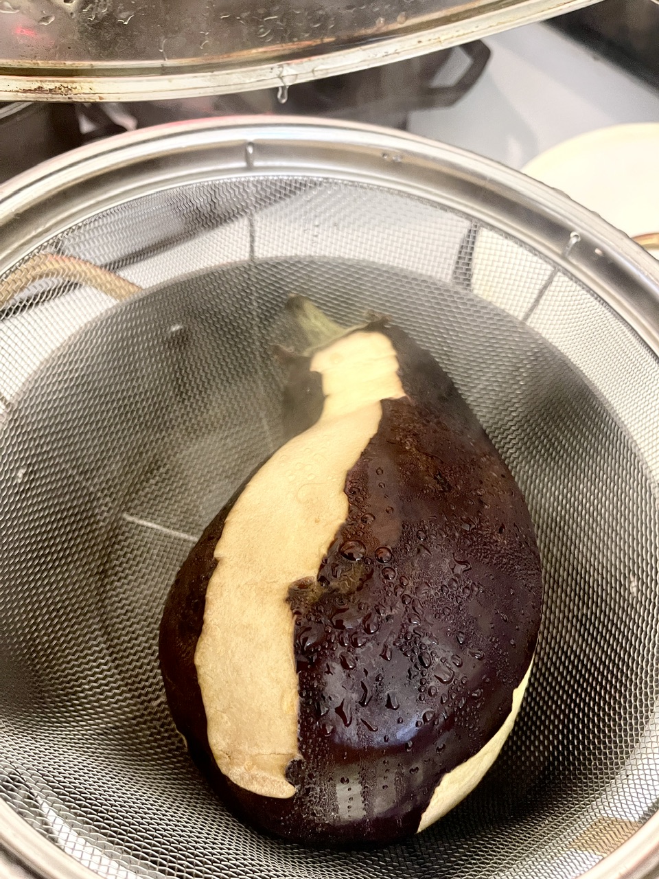 Cooking vegan eggplant unagi in a steamer for crispy texture.