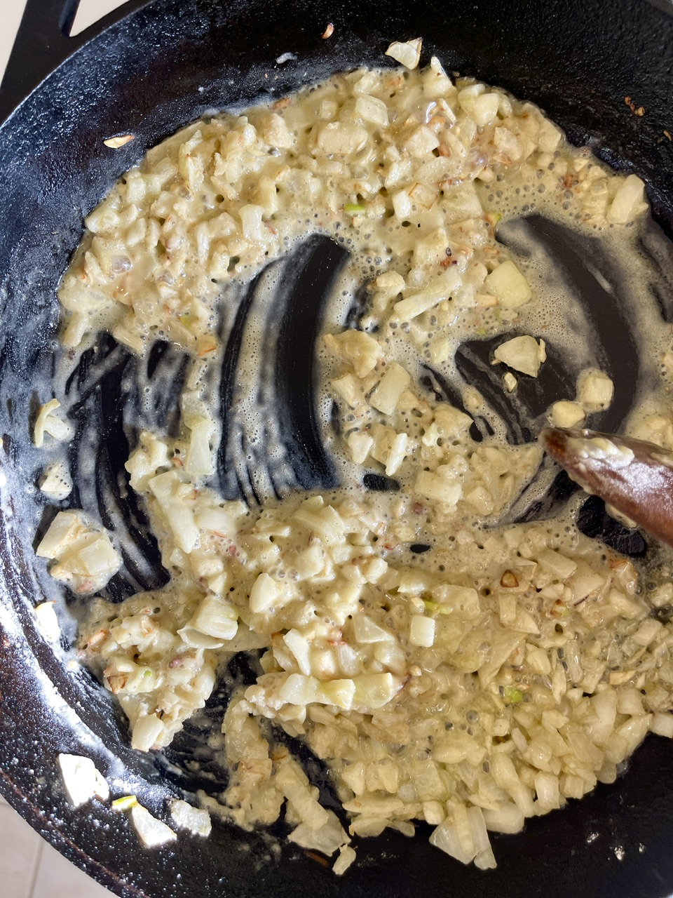Sautéed garlic and onions in a skillet for vegan pasta dish.
