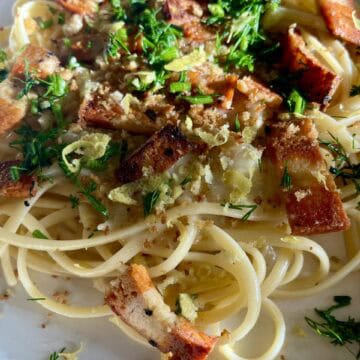 Vegan garlic linguine with crispy vegan bacon and fresh herbs.