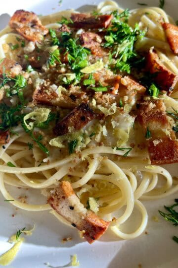 Vegan garlic linguine with crispy vegan bacon and fresh herbs.